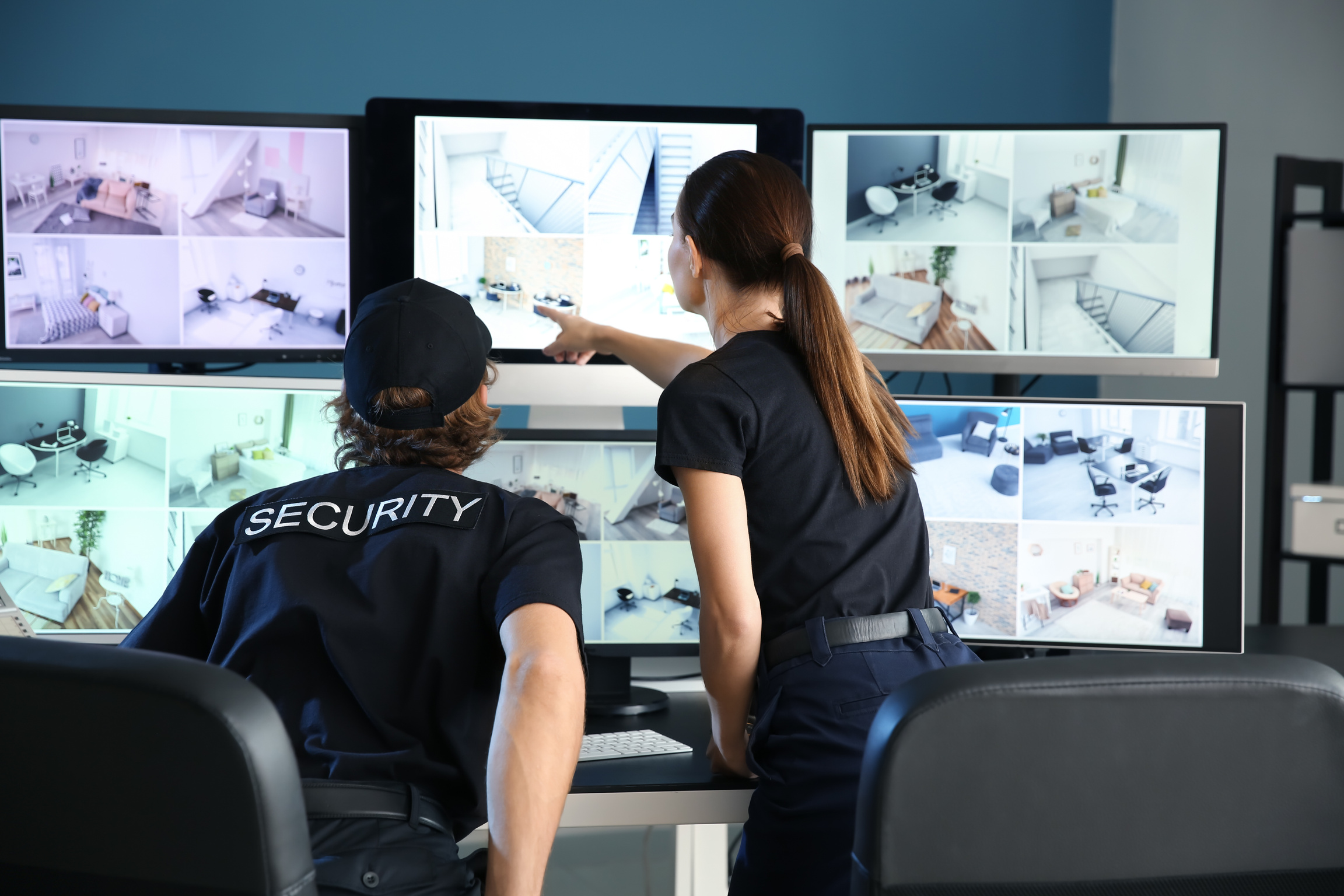 Security Guards Monitoring Modern CCTV Cameras in Surveillance Room